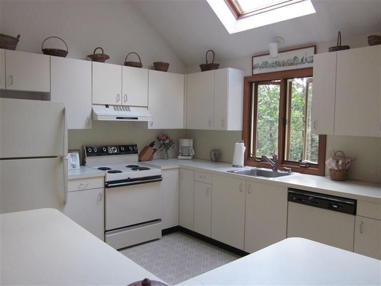 64 Day Road Wellfleet, MA 02667 - Photo 2 of 24 a kitchen with a sink white cabinets and white appliances