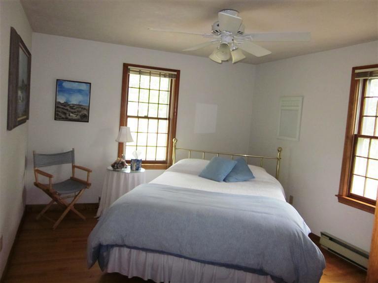 64 Day Road Wellfleet, MA 02667 - Photo 7 of 24 a bedroom with a bed a chandelier and a window
