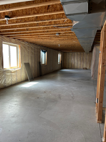 175 North 100th West Centerfield, UT 84622 - Photo 31 of 32 Expansive unfinished basement featuring a concrete floor, exposed wood ceiling joists, and multiple windows