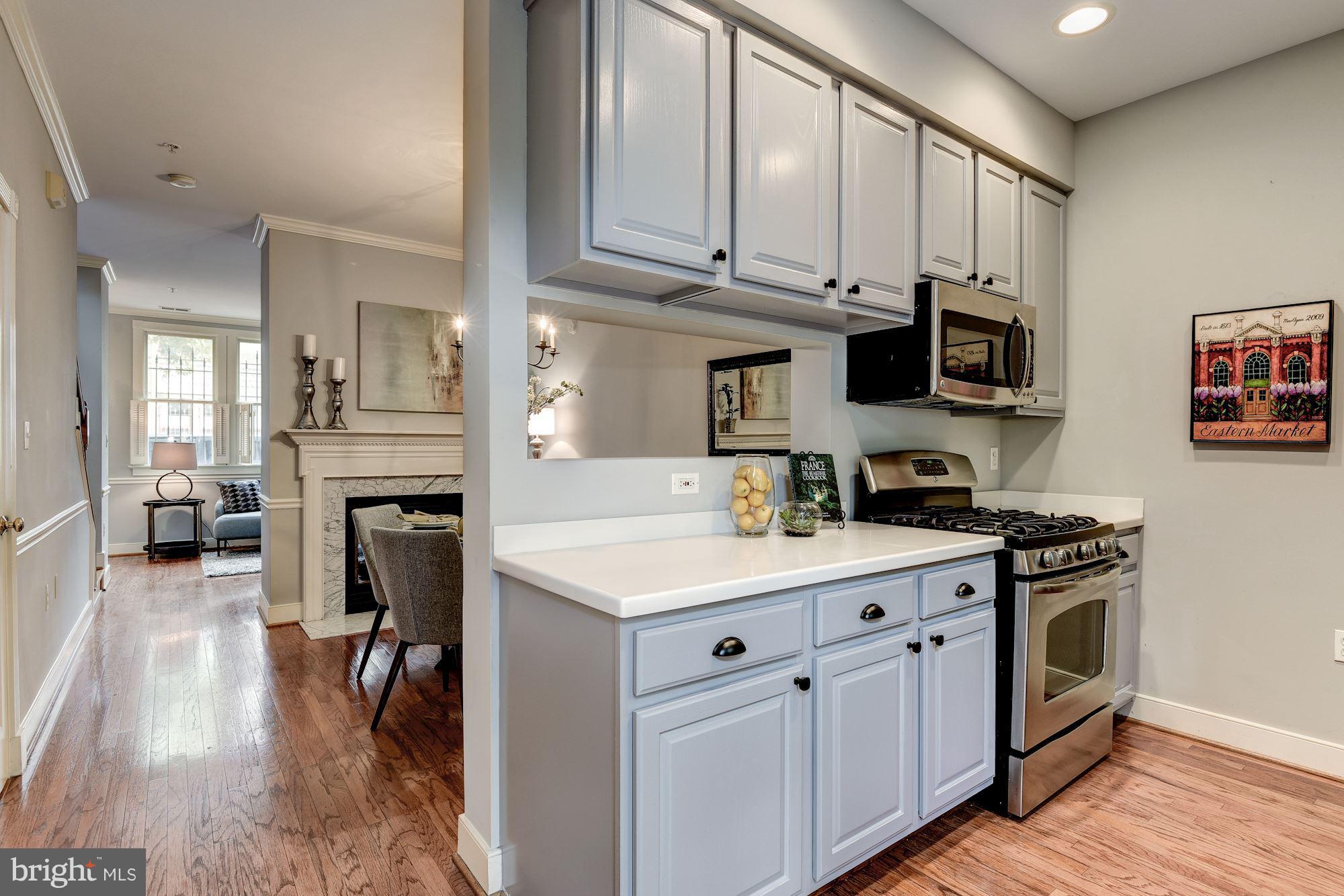 625 Ellen Wilson Place Southeast Washington, DC 20003 - Photo 7 of 26 a kitchen with stainless steel appliances granite countertop a stove top oven a sink a dining table and chairs with wooden floor