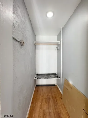 a view of a room with wooden floor and white walls