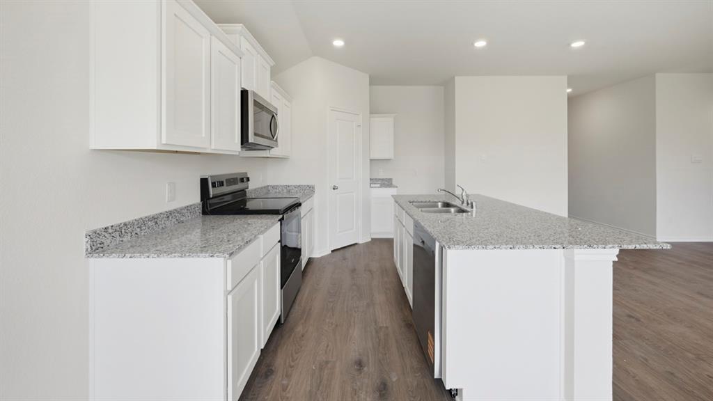 513 Wild Rose Way Princeton, TX 75407 - Photo 19 of 34 a kitchen that has a microwave a sink and a stove in it