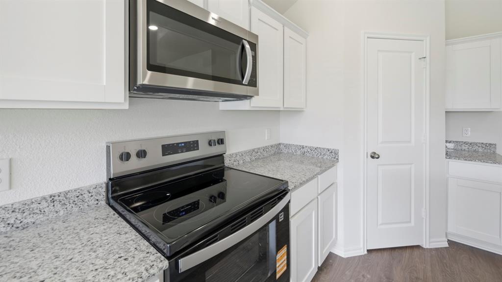 513 Wild Rose Way Princeton, TX 75407 - Photo 24 of 34 a kitchen with a stove and a microwave