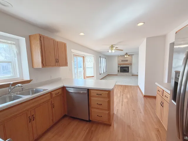 a kitchen with a sink a refrigerator and wooden floor