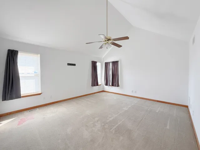 an empty room with a window and a ceiling fan