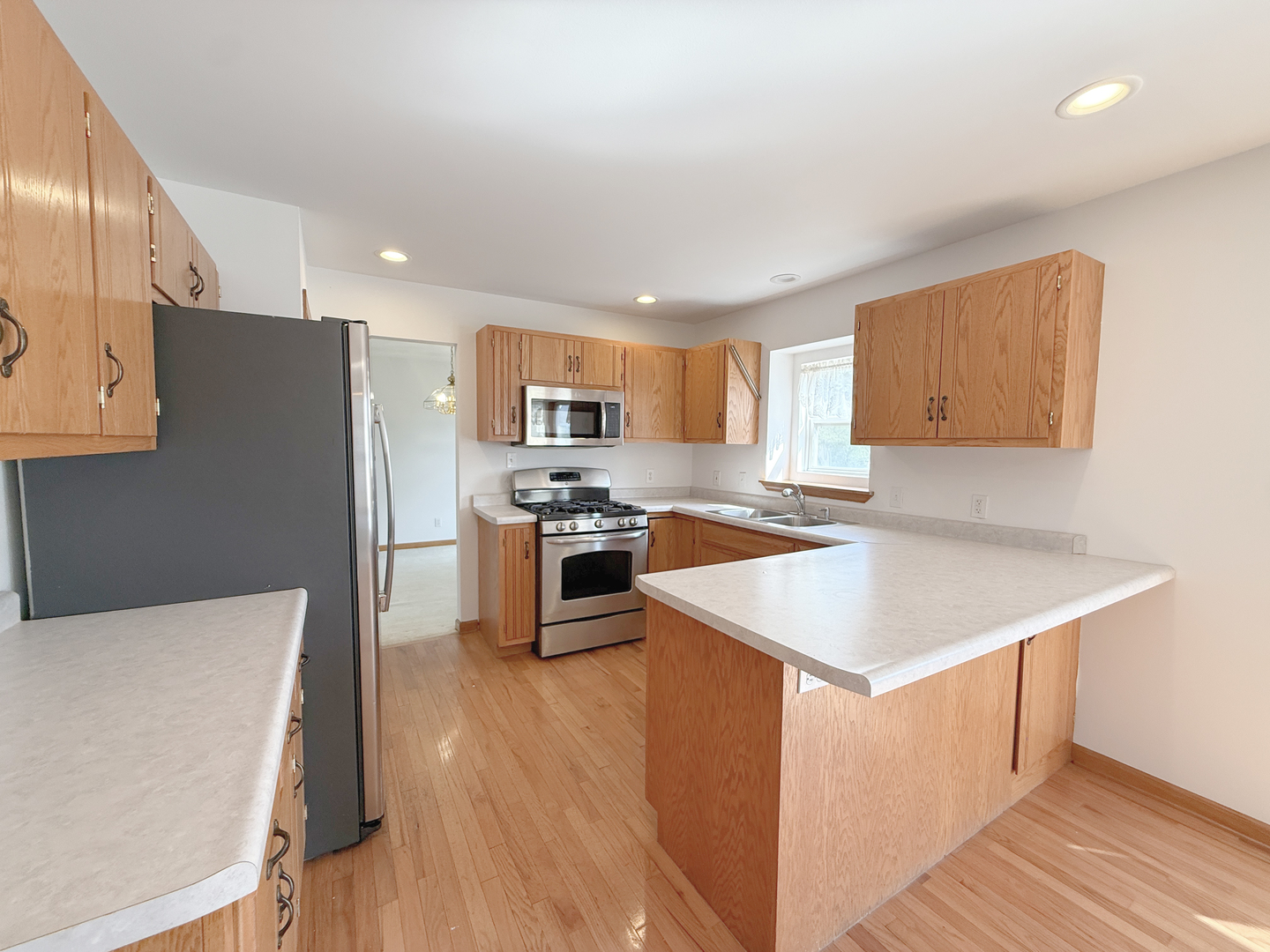 1278 Knolls Avenue South DeKalb, IL 60115 - Photo 9 of 35 a kitchen with a refrigerator a stove top oven a sink dishwasher and wooden cabinets with wooden floor