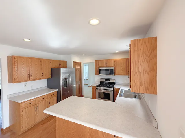 a kitchen with stainless steel appliances a refrigerator and a stove top oven