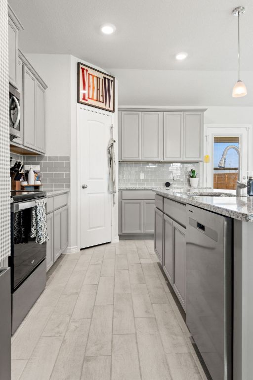 213 Gauge Road Thorndale, TX 76577 - Photo 17 of 40 a kitchen with stainless steel appliances granite countertop a refrigerator and a stove top oven