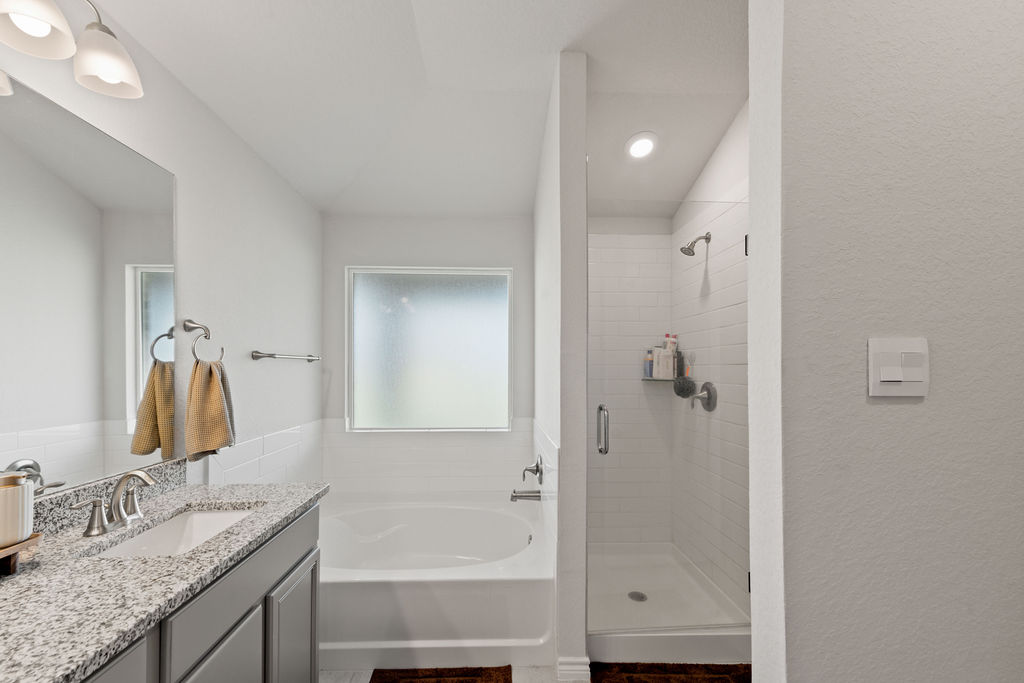 213 Gauge Road Thorndale, TX 76577 - Photo 23 of 40 a bathroom with a granite countertop sink tub and mirror