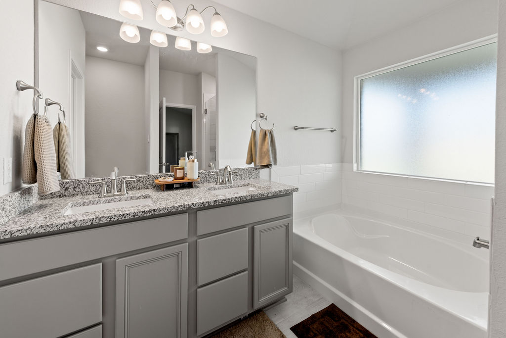 213 Gauge Road Thorndale, TX 76577 - Photo 24 of 40 a bathroom with a granite countertop sink a large mirror and a bathtub