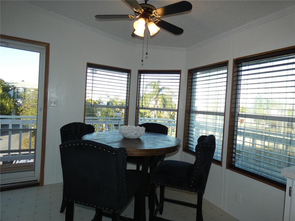 6814 Gull Lane Hudson, FL 34667 - Photo 28 of 51 a dining room with furniture a chandelier and a large window