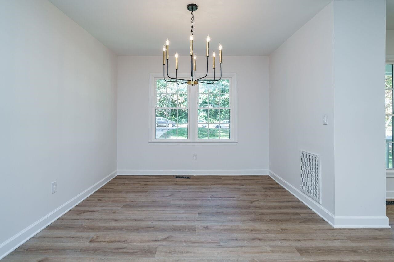 1436 Princess Anne Road Raleigh, NC 27607 - Photo 12 of 36 a view of an empty room with wooden floor and a window