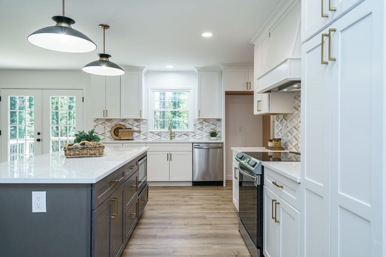 1436 Princess Anne Road Raleigh, NC 27607 - Photo 9 of 36 a kitchen with a sink dishwasher stove and white cabinets with wooden floor