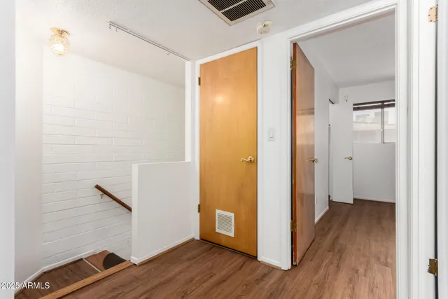 a view of a hallway with wooden floor and closet
