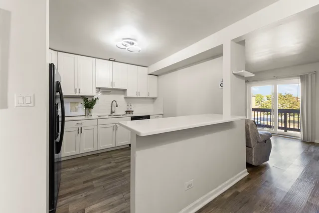 a kitchen with a refrigerator a stove a sink dishwasher and a oven with wooden floor