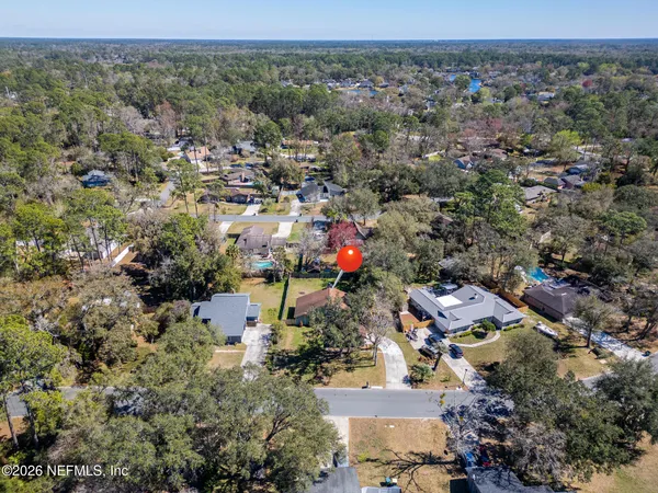 an aerial view of a house with a yard and large tree