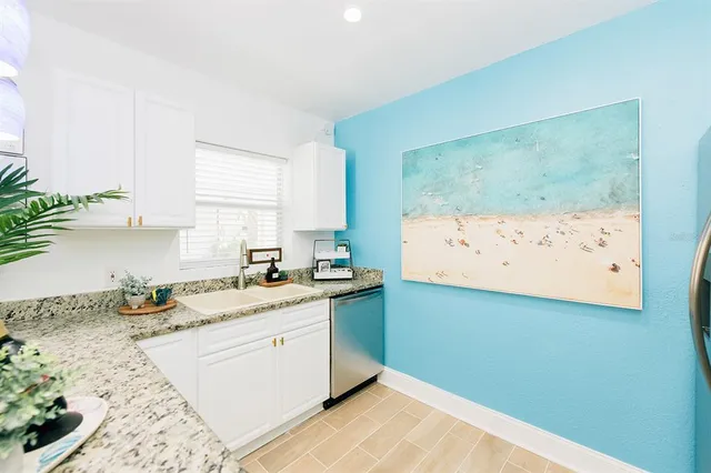 a kitchen with a sink cabinets and wooden floor