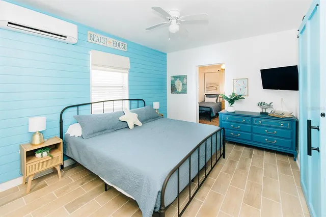 a bedroom with a bed and a flat tv screen on dresser