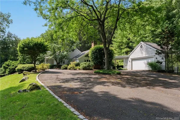 a view of white house with a yard and potted plants