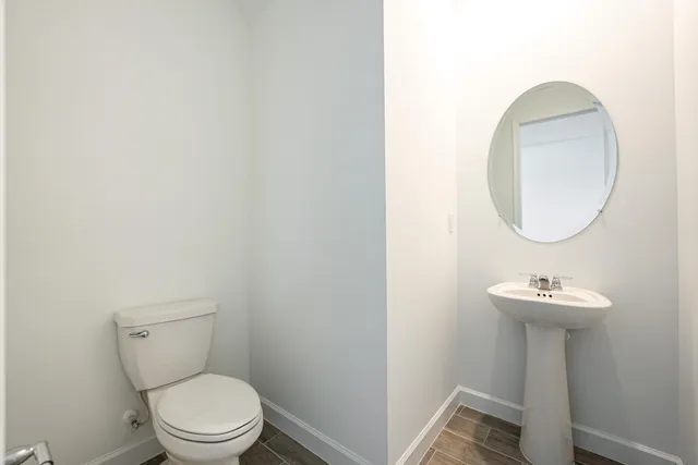 a bathroom with a sink toilet and a mirror