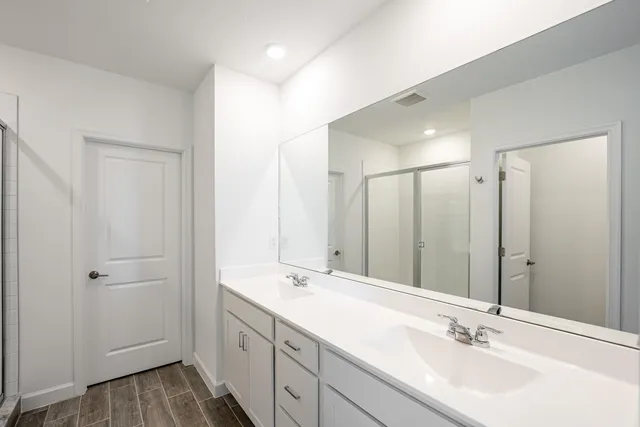 a bathroom with double vanity sink and a mirror