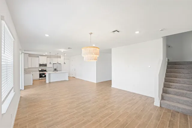 a view of a kitchen with wooden floor and electronic appliances