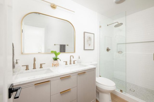 a bathroom with a sink a toilet and shower