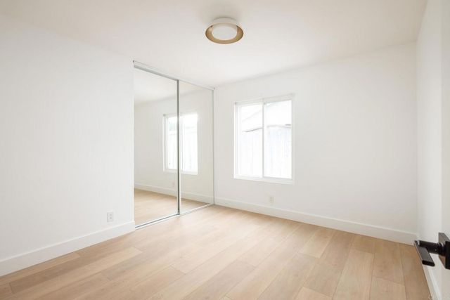 an empty room with windows and closet