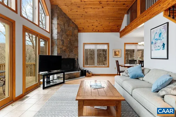 a living room with furniture a flat screen tv and a floor to ceiling window