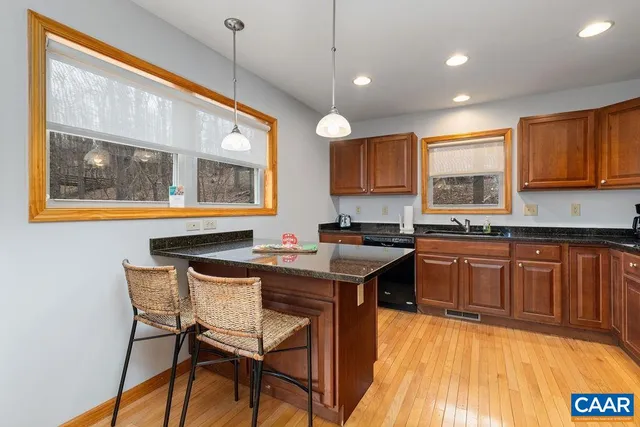 a kitchen with stainless steel appliances granite countertop a stove a sink dishwasher and a microwave oven with cabinets