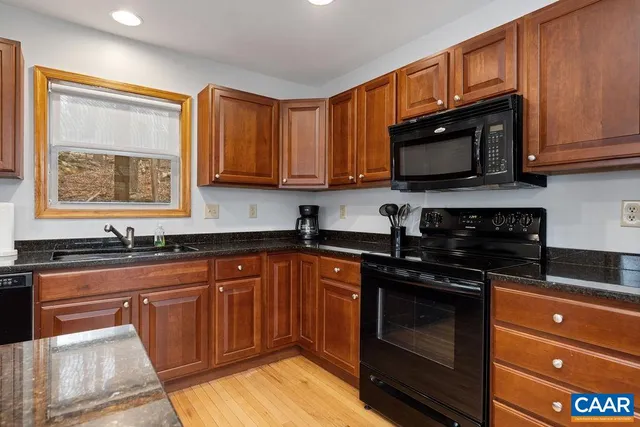 a kitchen with stainless steel appliances granite countertop a stove a refrigerator and a sink