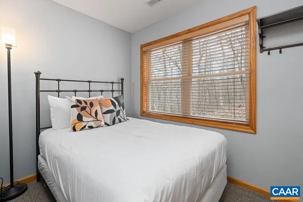 a bedroom with a bed and a large window