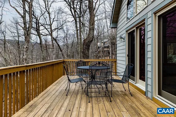 a balcony with wooden floor and trees