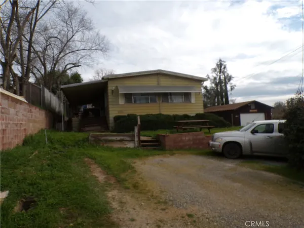a front view of a house with a garden and parking
