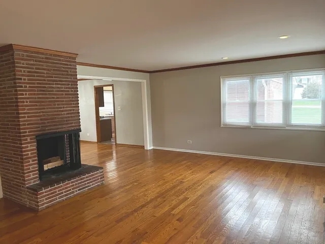 an empty room with chandelier fan and windows