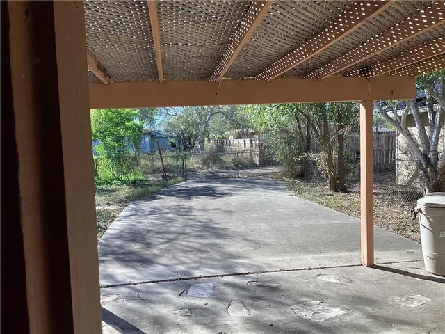 a backyard of a house with large trees and plants