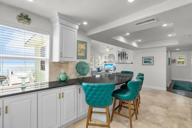 a kitchen with kitchen island granite countertop a sink and a large window