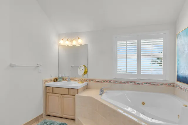 a spacious bathroom with a tub sink and mirror