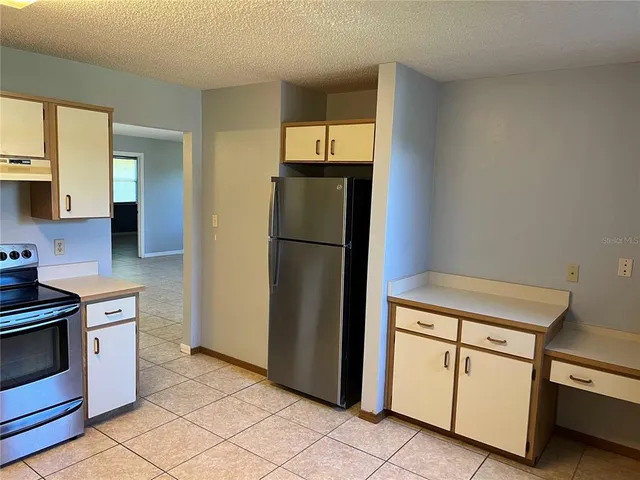 a kitchen with a stove refrigerator and cabinets