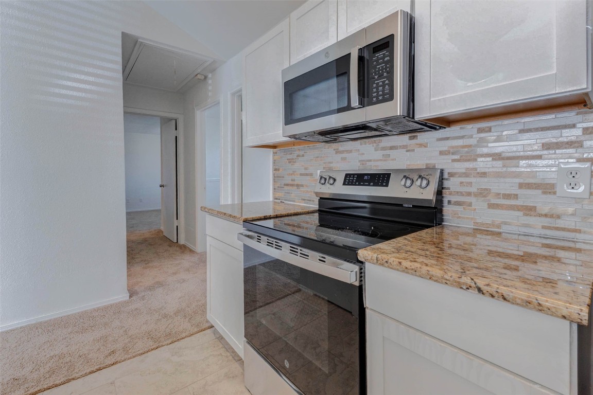 5210 Shirley Street Baytown, TX 77521 - Photo 14 of 31 a kitchen with granite countertop a stove and a microwave