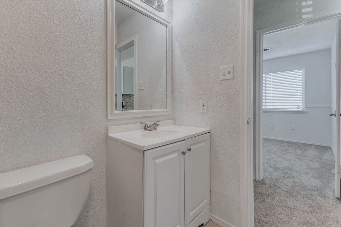 5210 Shirley Street Baytown, TX 77521 - Photo 19 of 31 a bathroom with a sink a toilet and a mirror