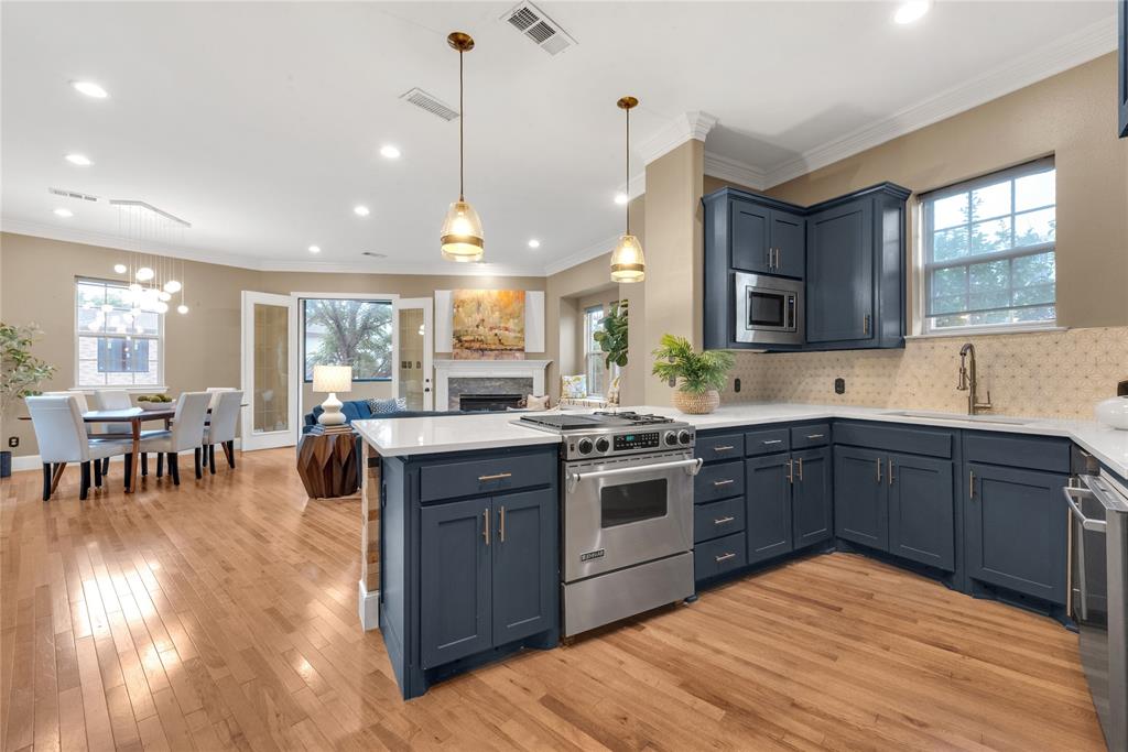 5102 Ridgedale Avenue Dallas, TX 75206 - Photo 9 of 27 Open-concept kitchen featuring shaker-style cabinetry, a built-in microwave, and stainless steel appliances