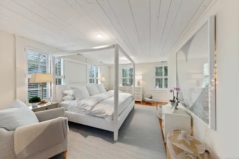 a bedroom with furniture and a large window