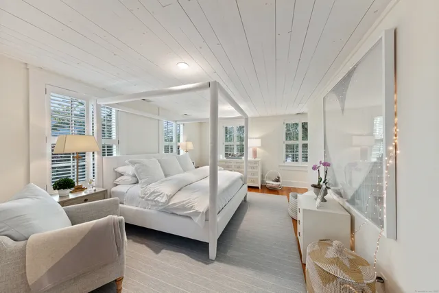 a bedroom with furniture and a large window