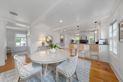 a living room with furniture kitchen view and a wooden floor