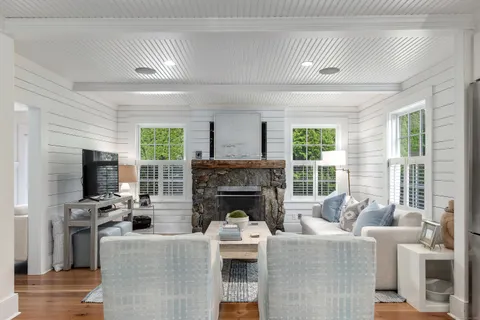 a living room with furniture a fireplace and a flat screen tv