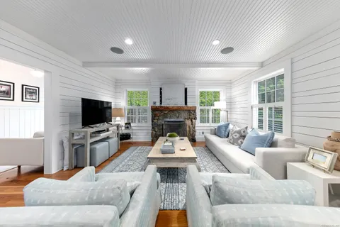 a living room with furniture a flat screen tv and a fireplace