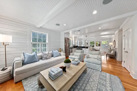 a living room with furniture wooden floor and a large window