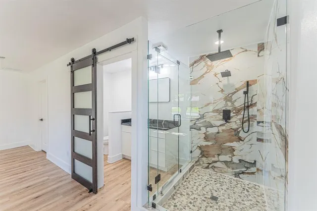 a bathroom with a glass shower door and a sink