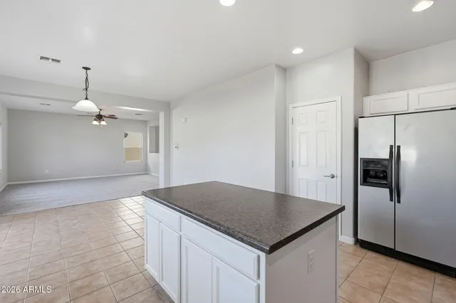 a kitchen with granite countertop a sink white cabinets and stainless steel appliances